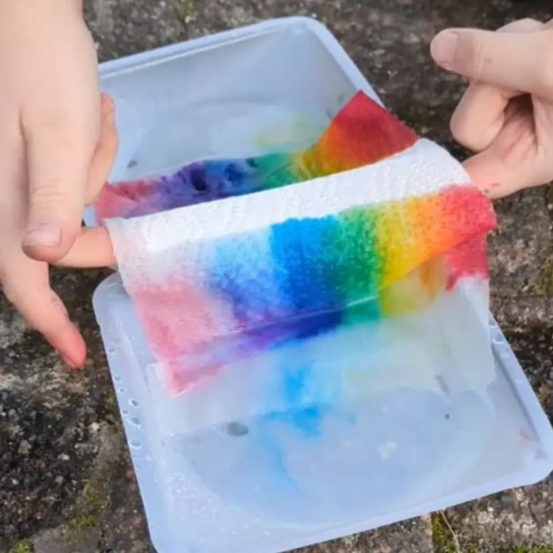 Bunte, mit Wasser angefeuchtete Papiertücher in einer Schüssel.